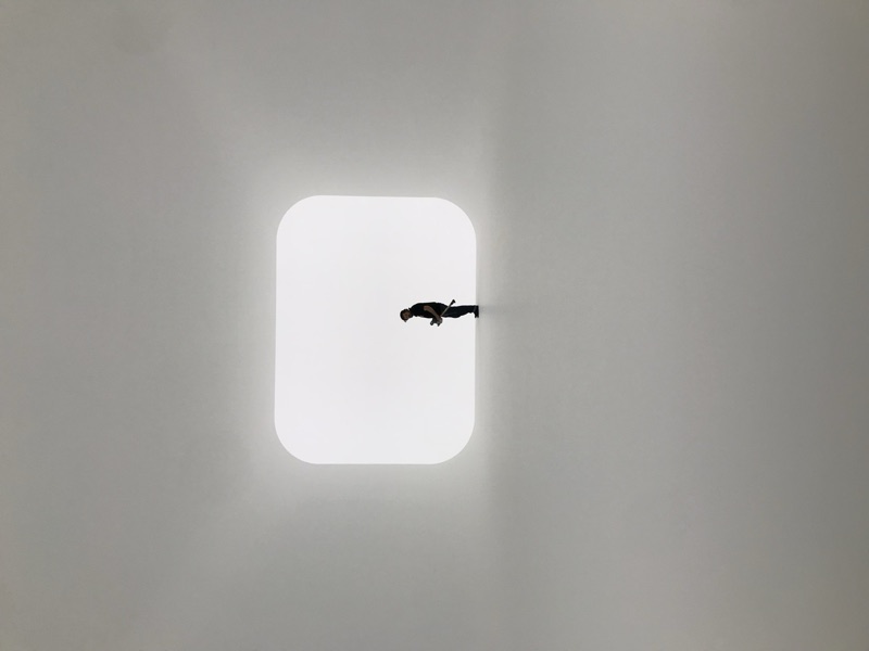 Minimalist light installation with silhouetted figure