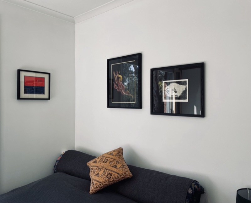 Three framed artworks above living room sofa
