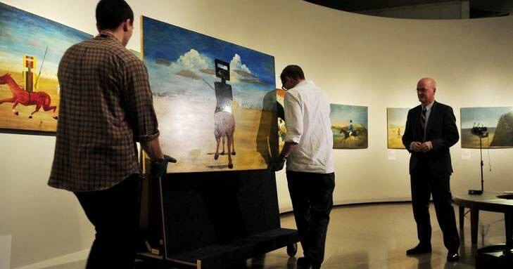 Installing paintings in gallery exhibition